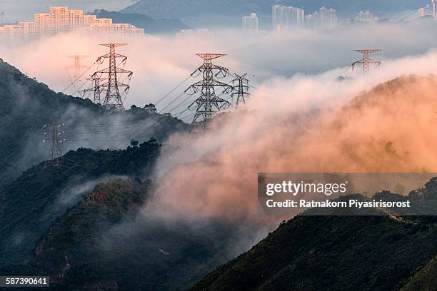 electrical power lines and pylons with misty - power grid stock-fotos und bilder