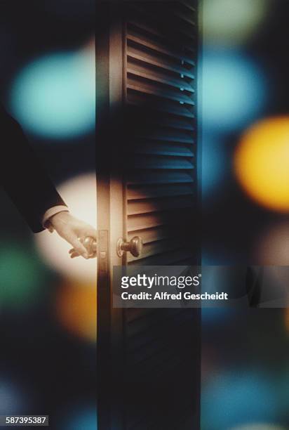 Man's hand opening a slatted door, 1982.