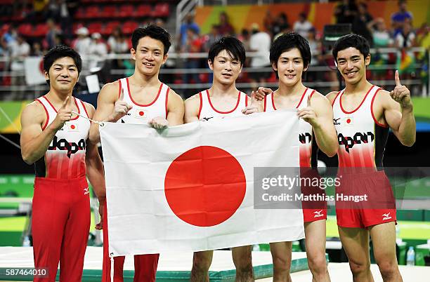 Koji Yamauro, Yusuke Tanaka, Kohei Uchimura, Ryohei Kato and Kenzo Shirai of Japan pose for photographs after winning the gold medal during the men's...