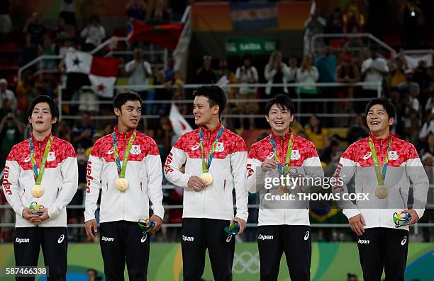 Japan's Ryohei Kato, Japan's Kenzo Shirai, Japan's Yusuke Tanaka, Japan's Kohei Uchimura and Japan's Koji Yamamuro pose with their gold medals on the...