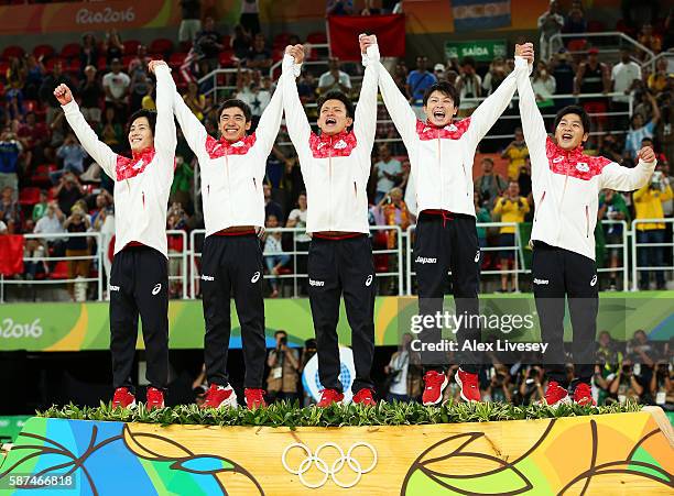 Gold medalists team Japan member Ryohei Kato, Kenzo Shirai, Yusuke Tanaka, Kohei Uchimura and Koji Yamamuro celebrate on the podium at the medal...