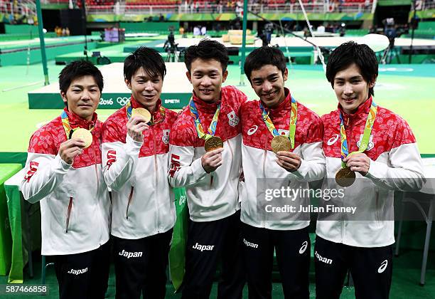 Gold medalists Koji Yamamuro, Kohei Uchimura, Yusuke Tanaka, Kenzo Shirai and Ryohei Kato of Japan pose for photogrpahs with their medals at the...