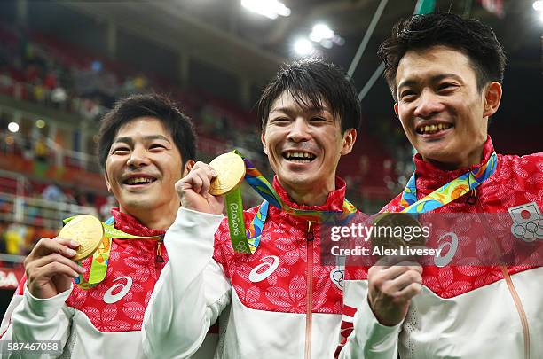 Gold medalists Koji Yamamuro, Kohei Uchimura and Yusuke Tanaka of Japan pose for photogrpahs with their medals at the medal ceremony for the men's...