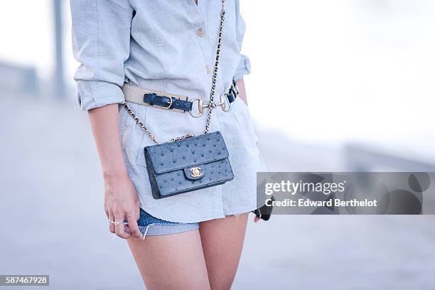 May Berthelot , is wearing an Asos gray shirt, a vintage horsebit belt, Levi's denim jeans shorts, Claudie Pierlot sandals, Saint Laurent YSL...