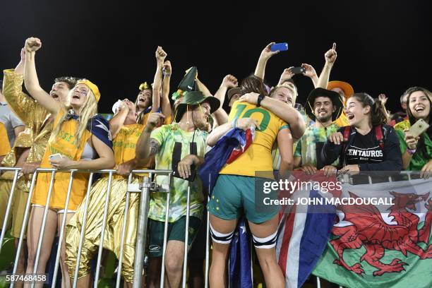 Australia's Alicia Quirk celebrates with a supporter after victory in the womens rugby sevens gold medal match between New Zealand and Australia...