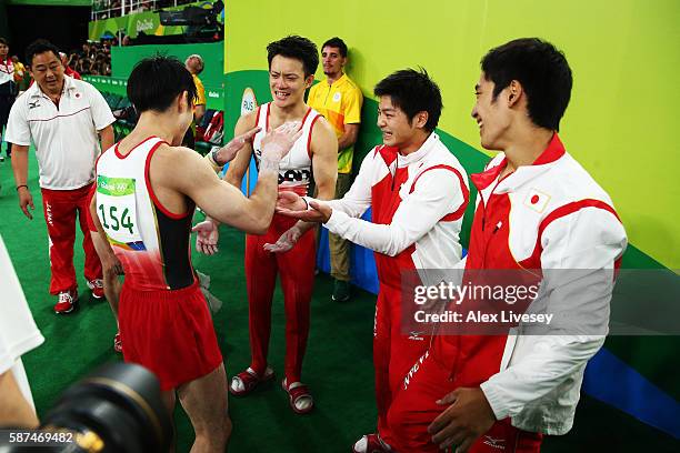 Kohei Uchimura of Japan celebrates his performance with his team mates Kenzo Shirai , Koji Yamamuro and Yusuke Tanaka during the men's team final on...