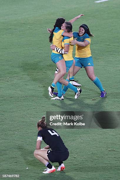 Charlotte Caslick, Chloe Dalton and Sharni Williams of Australia celebrate victory as Niall Williams of New Zealand looks dejected after the Women's...