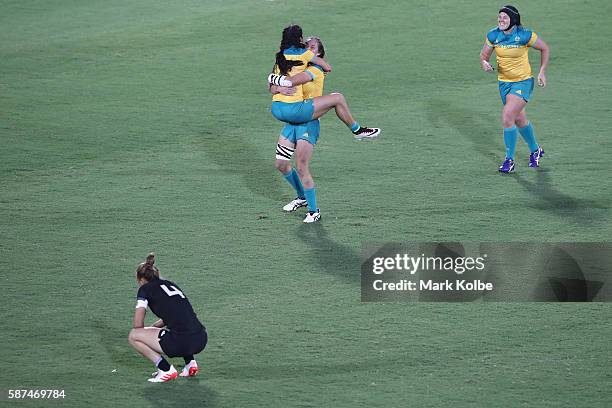 Charlotte Caslick, Chloe Dalton and Sharni Williams of Australia celebrate victory as Niall Williams of New Zealand looks dejected after the Women's...