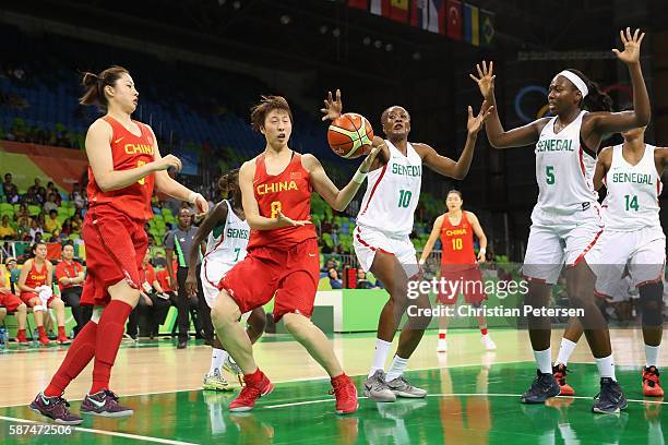 Di Wu of China and Astou Traore of Senegal reach for a loose ball during the women's basketball game on Day 3 of the Rio 2016 Olympic Games at the...