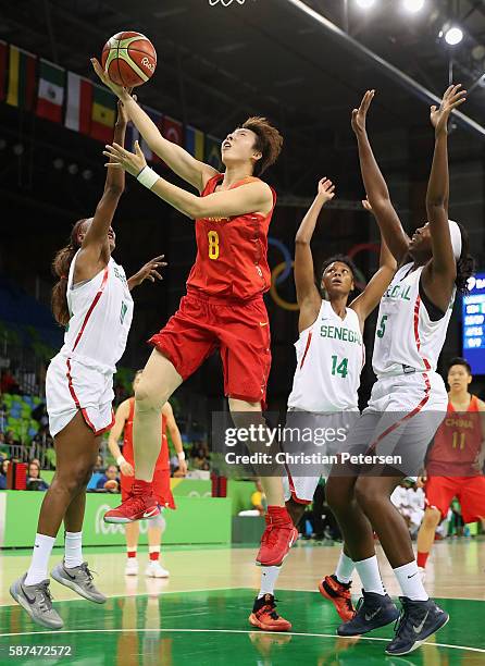 Di Wu of China attempts a shot past Marie-Sadio Rosche and Aya Traore of Senegal during the women's basketball game on Day 3 of the Rio 2016 Olympic...