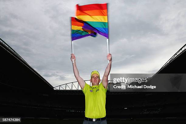 Goal umpire Michael Craig waves the Pride Game rainbow goal umpire flag during an AFL media opportunity at Etihad Stadium on August 9, 2016 in...