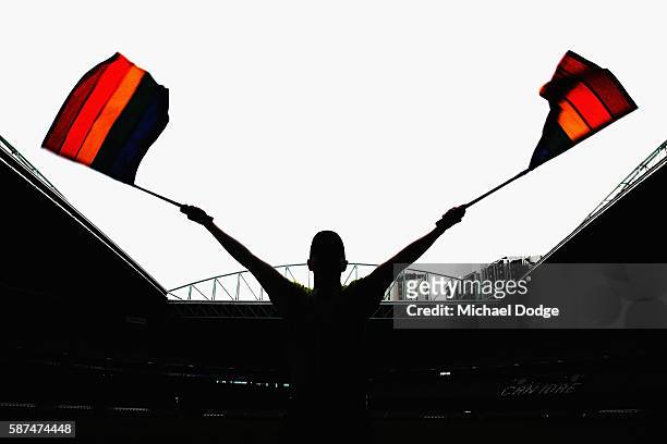 Goal umpire Michael Craig waves the Pride Game rainbow goal umpire flags during an AFL media opportunity at Etihad Stadium on August 9, 2016 in...
