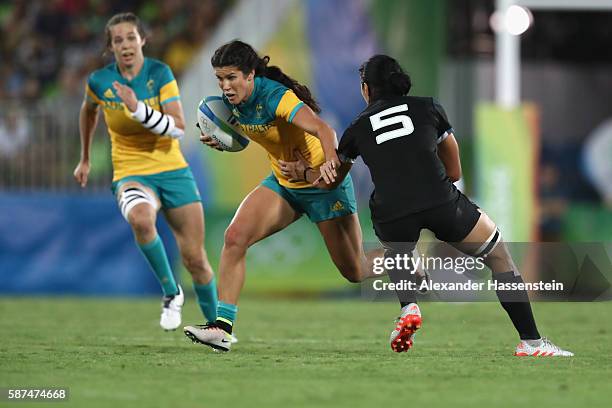 Charlotte Caslick of Australia is tackled by Sarah Goss of New Zealand during the Women's Gold Medal Rugby Sevens match between Australia and New...