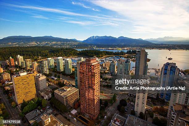 view of stanley park, vancouver harbour, english bay and the surrounding skyscrapers and mountains, vancouver, british columbia, canada - vancouver skyline stock pictures, royalty-free photos & images