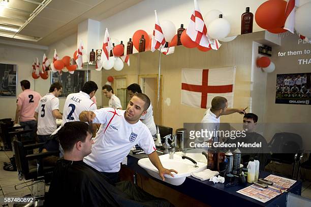 Turkish-run barber shop in central London, which has been festooned with strings of England flags and red and white balloons, is busy shortly before...
