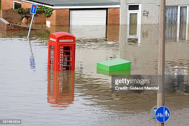 Traditional English phone box is partly submerged on one of the flooded streets of Catcliffe Village. This was one of the communities flooded when a...