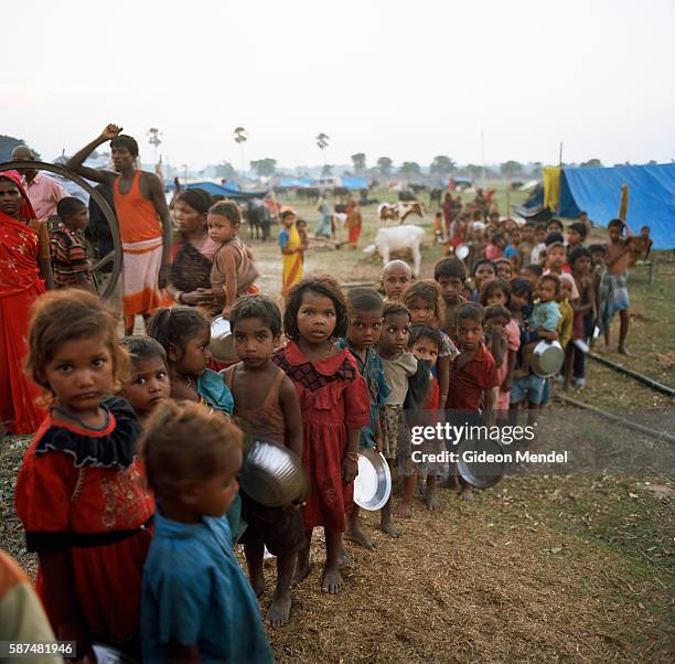 Children queue for a meal of khichri provided by a community kitchen in Gaushala camp for displaced people from Pir-muhammadpur village on the banks...