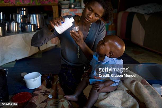 Mathato Notsi , measures out the twice daily dose of anti retroviral medicines for her baby Mpho. Mathato discovered that she and her baby are HIV...