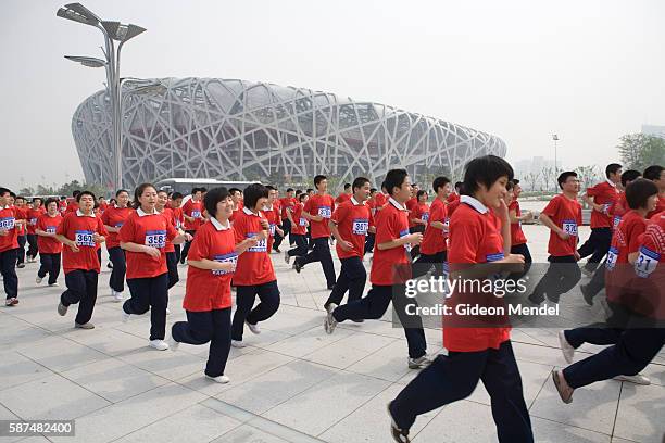 With the striking Beijing National Stadium looming in the background some of a group of approximately 10,000 runners set off on a 13 km marathon fun...
