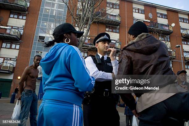 Policeman listens to the complaints of a young black resident of a council estate in Hackney. He, and a group of others from the area were accusing...