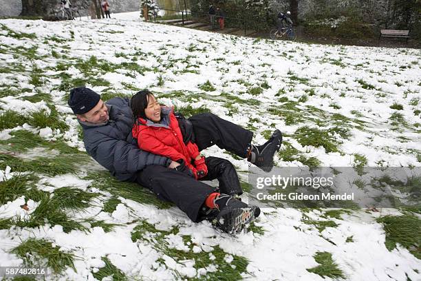 Father slides down a hill in Springfield Park on an improvised sled with his adopted Chinese daughter. This was after an unseasonal snowfall in...