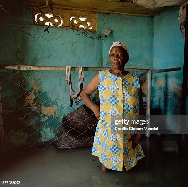 Christa Raymond Fils faces the camera in her flooded home in Decade in southeast Haiti. Her house was flooded and damaged by Hurricane Gustav. During...