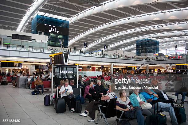 Passengers pass the time as they wait for their flights at the new Heathrow Terminal 5 building. This departure hall has an architecturally...