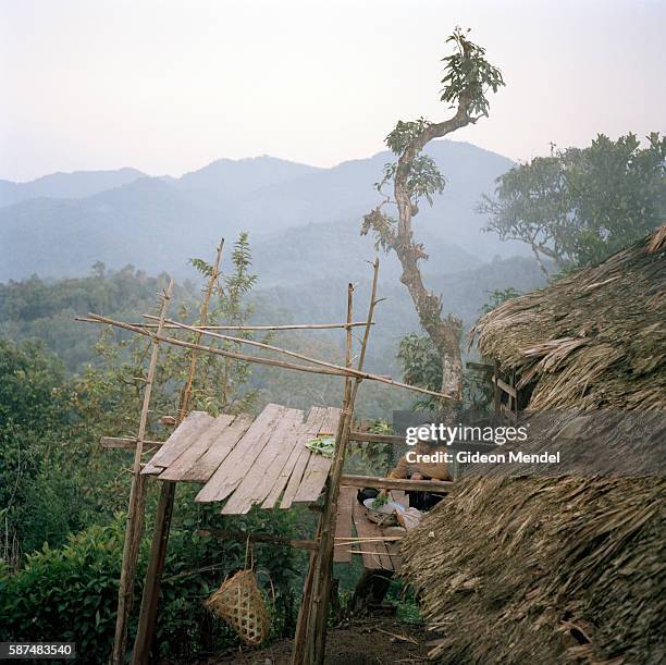 An Akha woman prepares the evening meal on the balcony of her traditional house in the Ban Nam Sa Akha village high up on a mountain slope in the Nam...