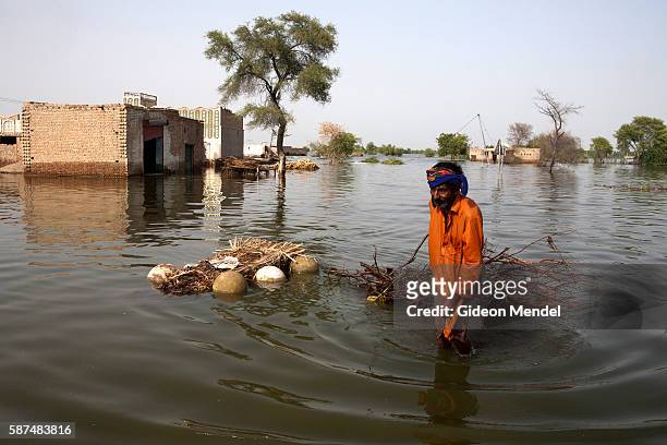 Man floats firewood through the flooded region close to Johi Barrage. The floods in Pakistan have affected 20 million people, destroying around 1.8...