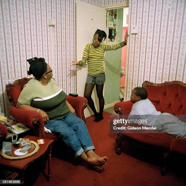 Mother talks to her angry teenage daughter while her brother looks on, in their flat on the Kingsmead Estate in Homerton in the eastern part of...