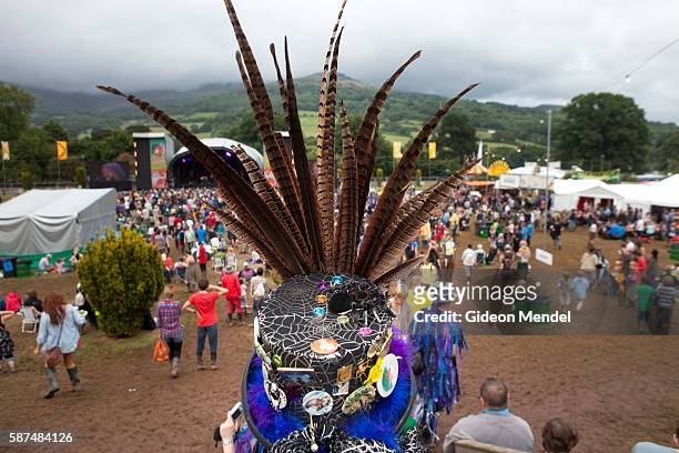 Morris dancer with an elaborate feathered hat walks through the Green Man festival. This is an independent music festival held annually in a stunning...