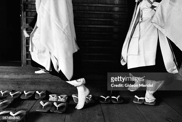 Priests take off their traditional footwear as they enter a temple in Koya-san.
