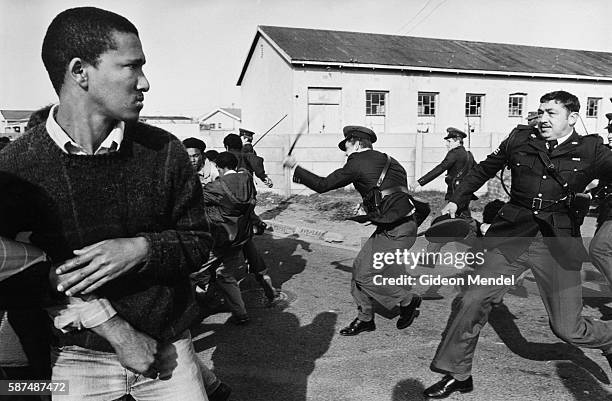 South African police officers charge a group of United Democratic Front demonstrators who are marching to Pollsmoor Prison in Cape Town in an attempt...