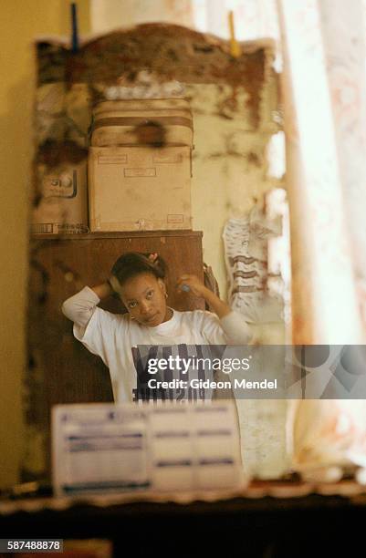 Sindi Sonya Ngidi, a 22-year-old HIV positive TAC activist from Umlazi township near Durban, combs her hair in front of the mirror prior to attending...