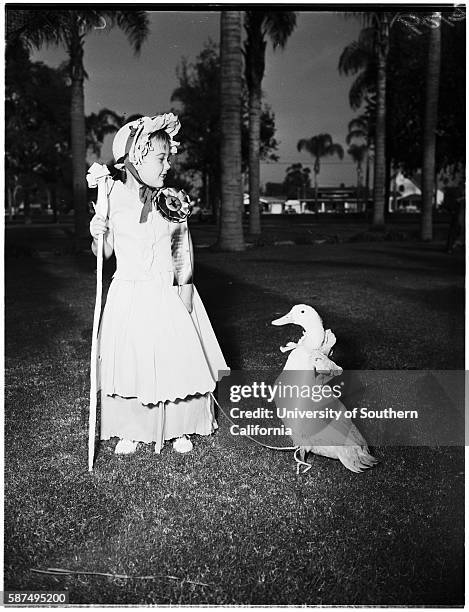 Girl in Little Bo Peep costume with duck on a leash.