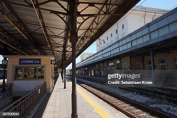 platform and train tracks at livorno central station, livorno, italy - livorno foto e immagini stock