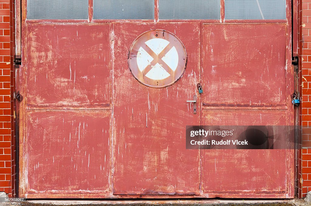 Old rusty metal gate with no parking road sign