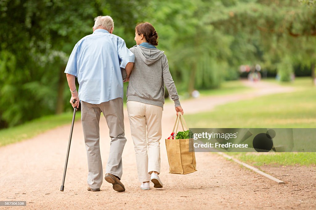 Caregiver – donna aiutando uomo anziano con lo shopping