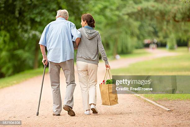 caregiver – woman helping senior man with shopping - 獨立 個照片及圖片檔