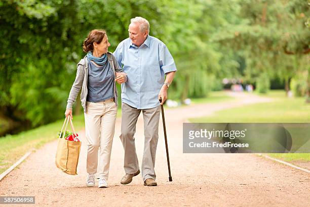 betreuer – frau hilft älteren mann beim einkaufen - client carer stock-fotos und bilder