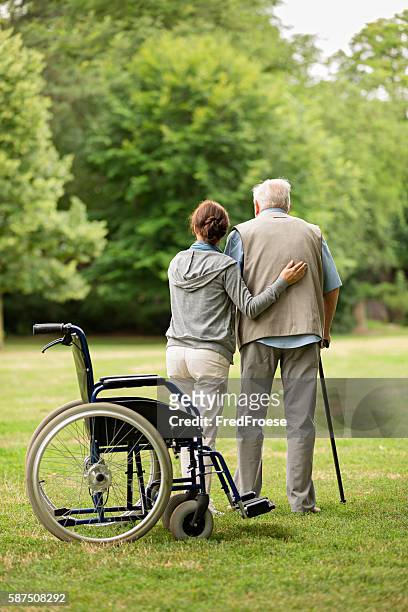 senior man with caregiver at the park - park service stock pictures, royalty-free photos & images
