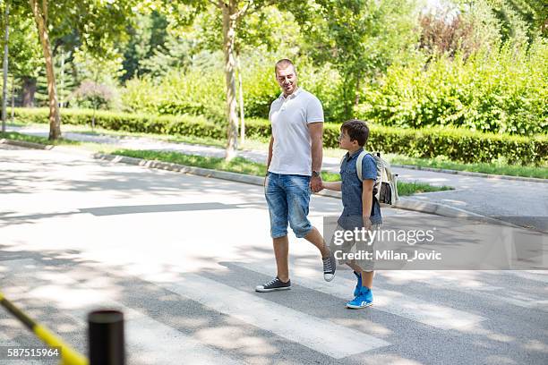 boy crossing the street with his father - man side way looking stock pictures, royalty-free photos & images