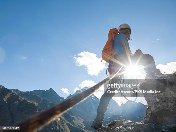 mountaineer looks off to distant mtns, on summit - hartnäckigkeit stock-fotos und bilder