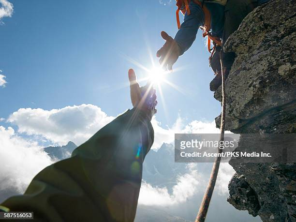 mountaineer offers helping hand to teammate, mtns - a helping hand stock pictures, royalty-free photos & images