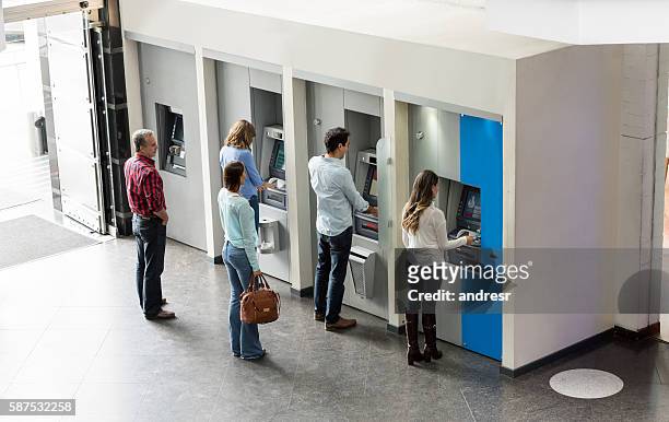 people withdrawing cash at an atm - people in a row stockfoto's en -beelden
