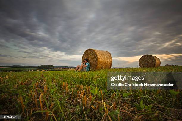man making photos in front of hay bale - low angle view of wheat growing on field against sky fotografías e imágenes de stock