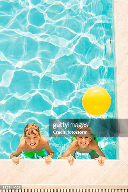 boys playing in swimming pool - beach ball pool stock pictures, royalty-free photos & images