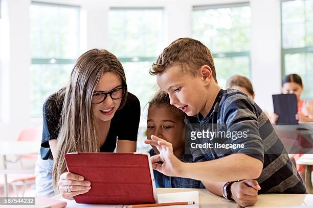 school kids in class using a digital tablet - elementary school building stock pictures, royalty-free photos & images