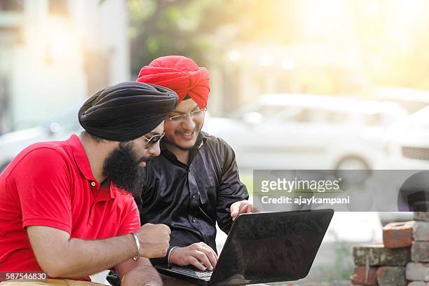 zwei sikh-männer mit laptop - punjab stock-fotos und bilder