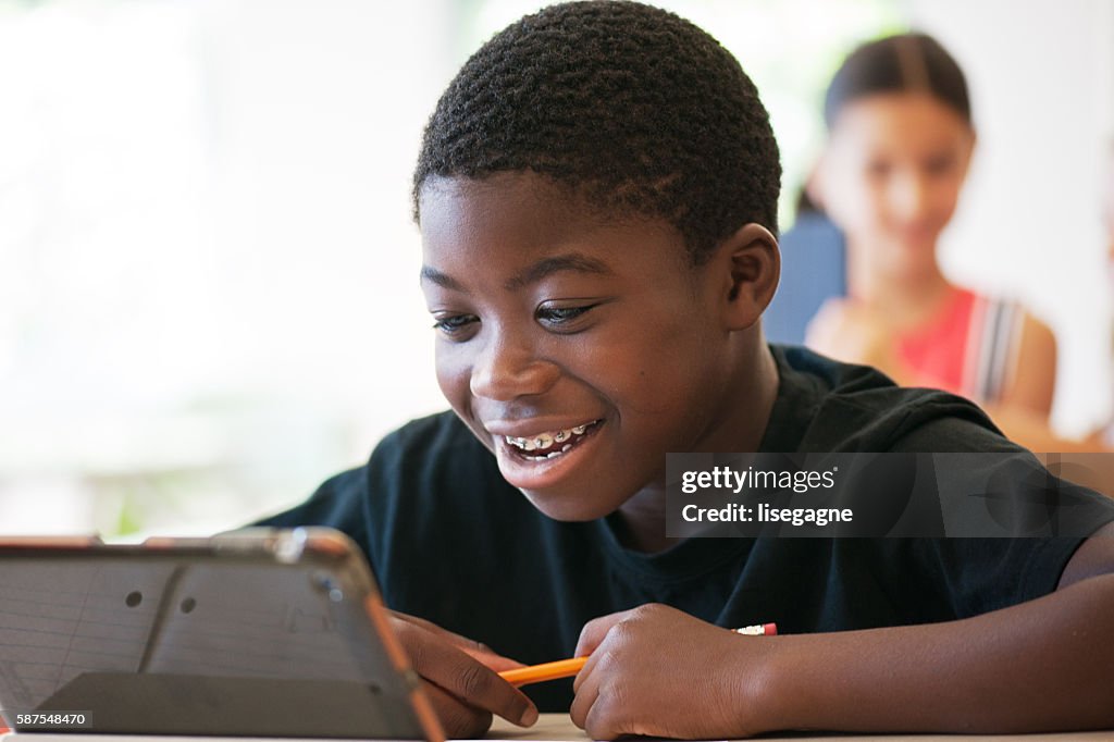 School kids in class using a digital tablet